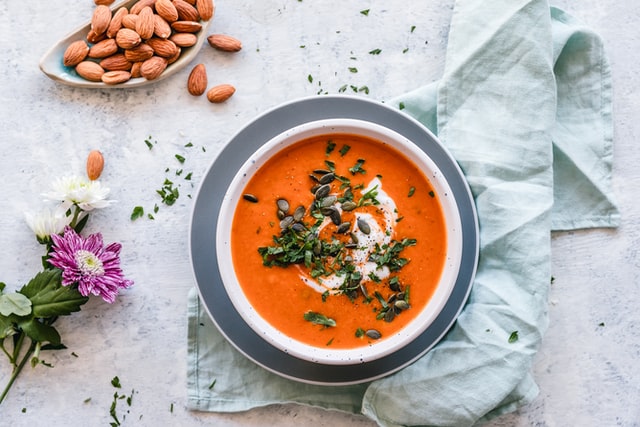 A top down picture of a butternut squash soup with a small splash of cream